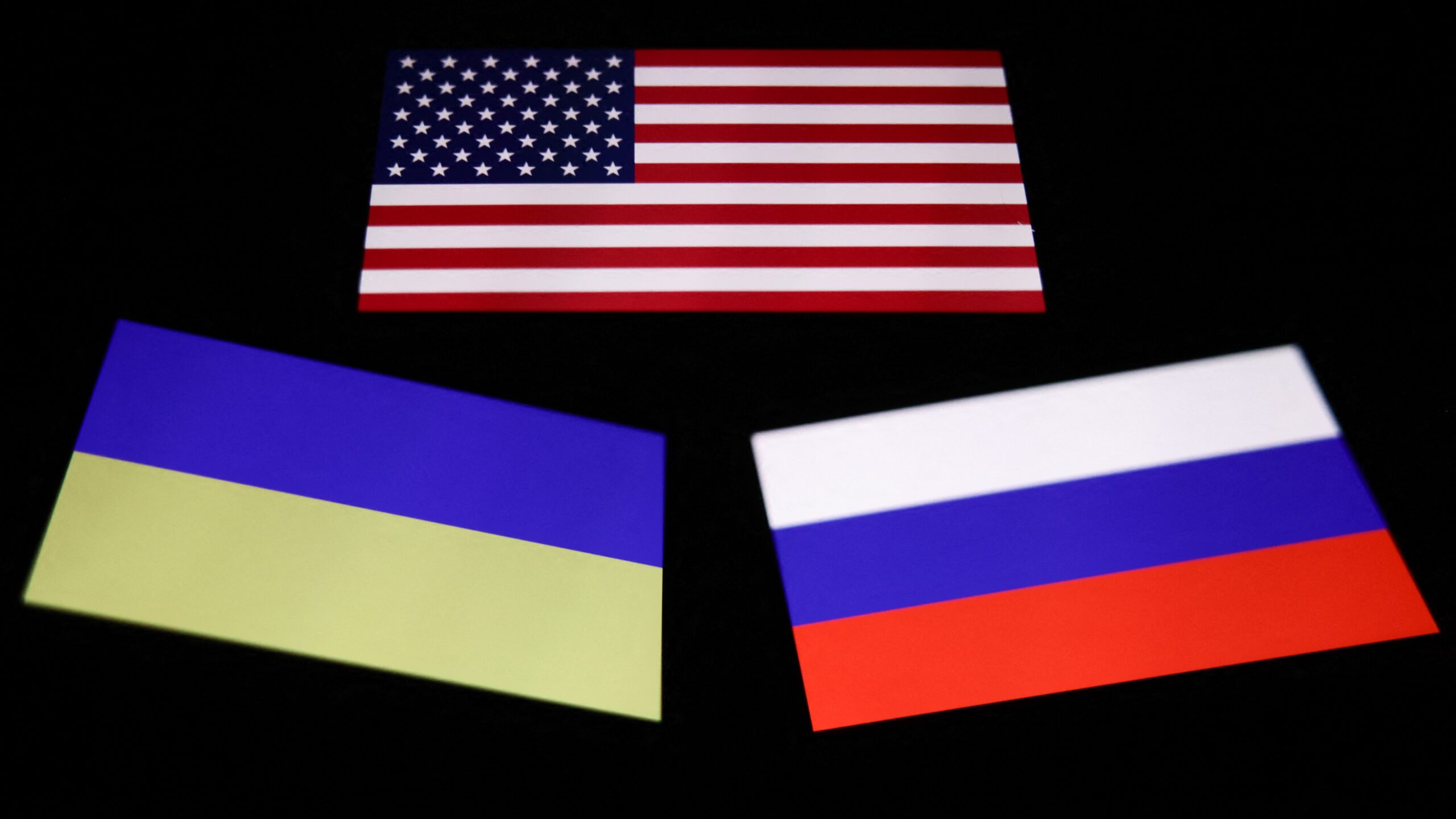 Flags of United States, Ukraine and Russia displayed on a phone screen are seen in this multiple exposure illustration photo taken in Krakow, Poland on January 7, 2025.